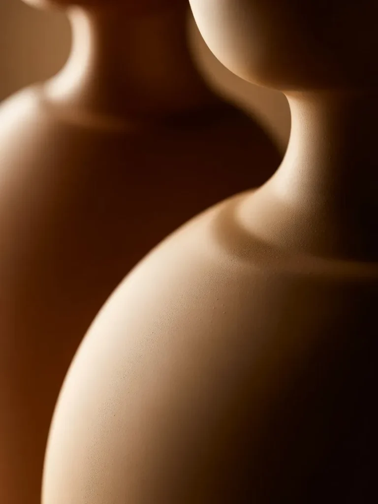 Detail shot highlighting the curved silhouette and matte texture of the Eilish perfume bottle set against a dark, cozy background.